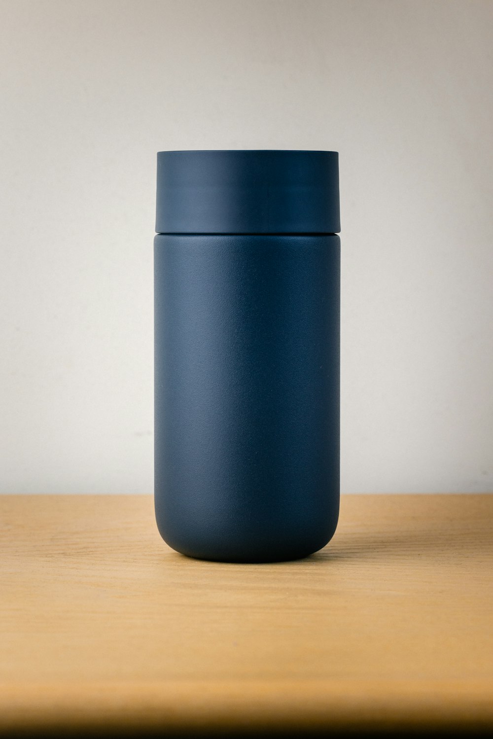 a blue cup sitting on top of a wooden table