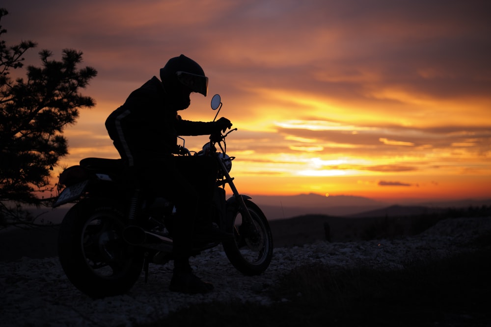 a man riding a motorcycle on top of a hill