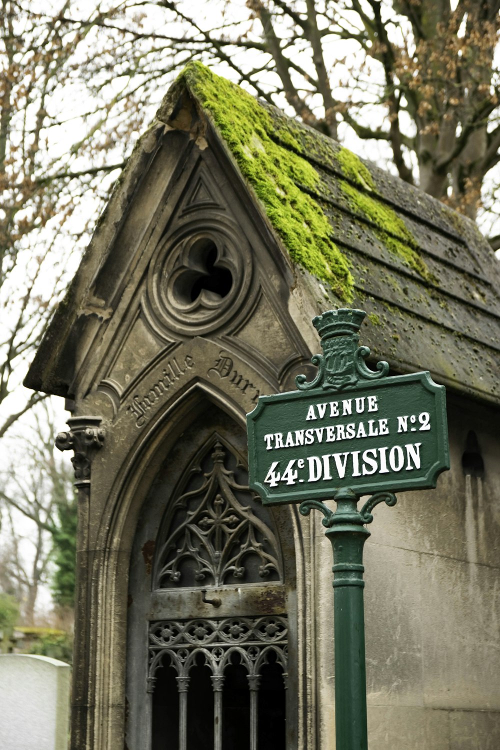 a green street sign sitting in front of a building