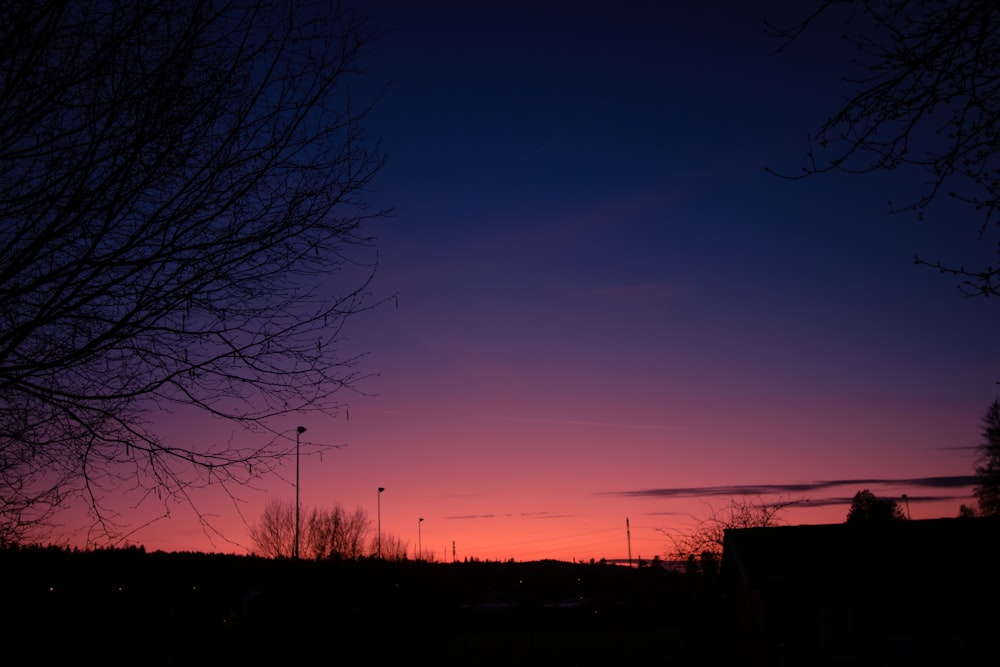 the sun is setting behind some trees