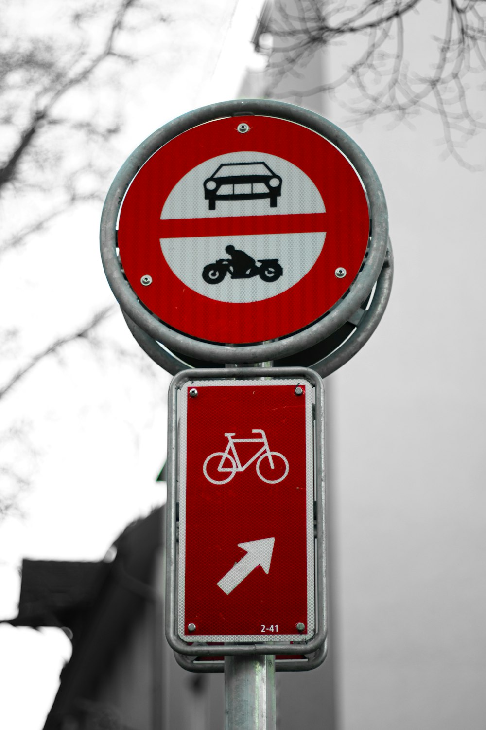 a red and white sign with a bicycle and bus on it
