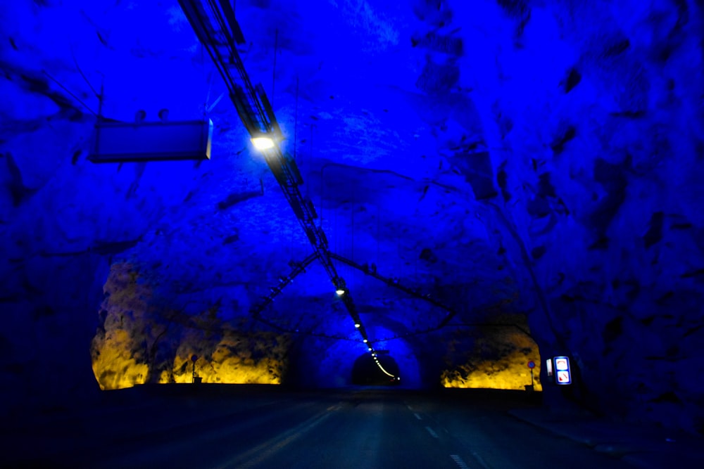 a car driving through a tunnel with blue lighting