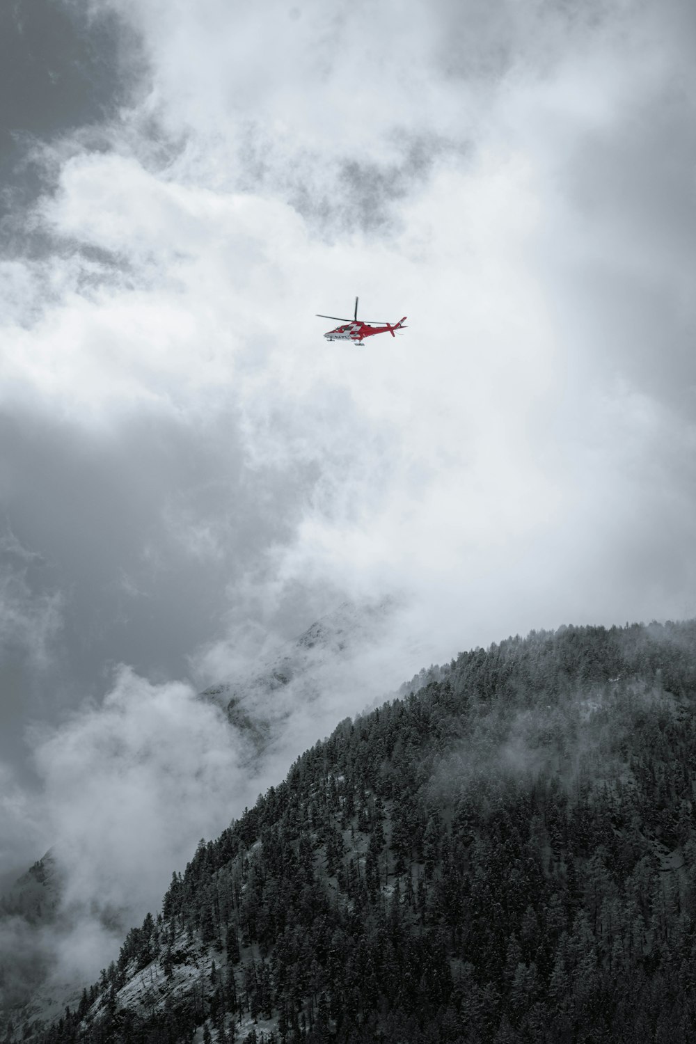 a plane flying over a mountain covered in clouds