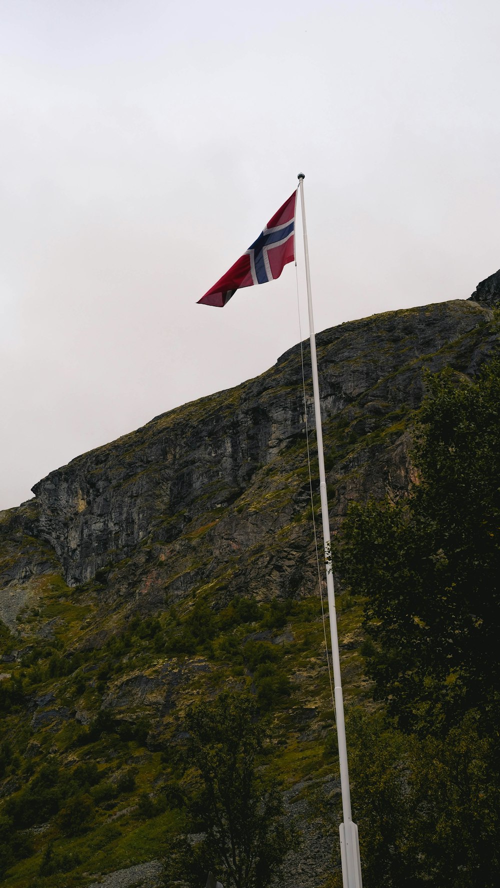 a flag on top of a mountain with a sky background
