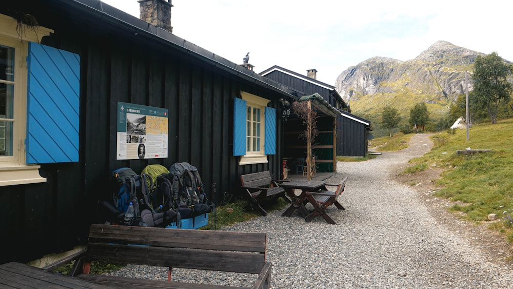 a wooden bench sitting next to a black building