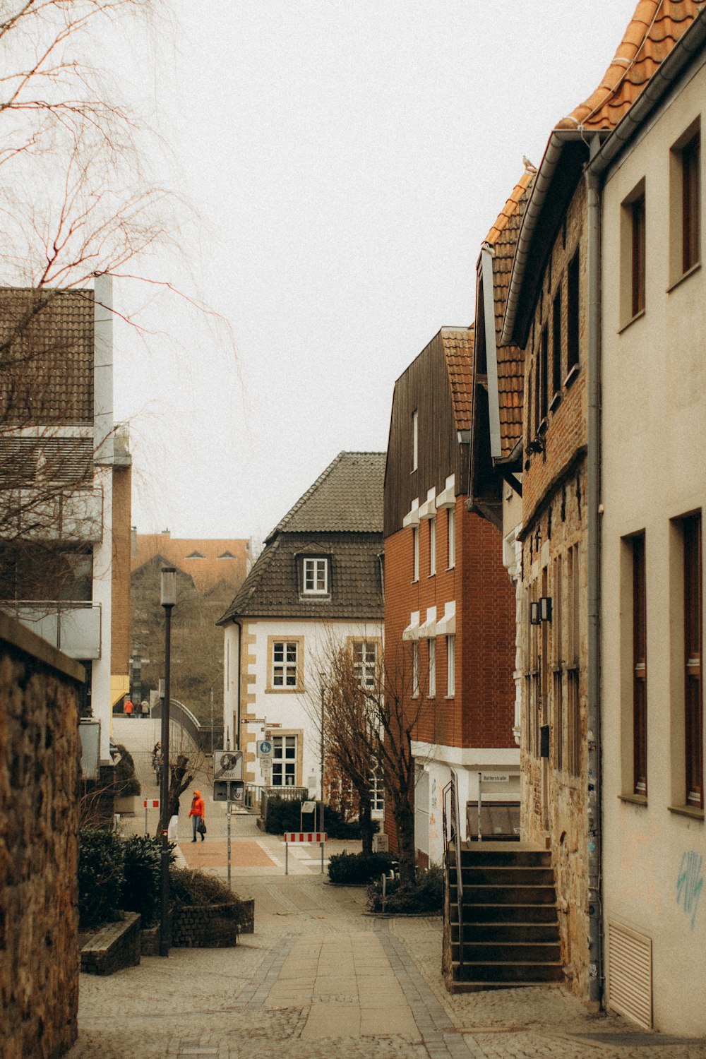 eine Person, die eine Kopfsteinpflasterstraße entlanggeht