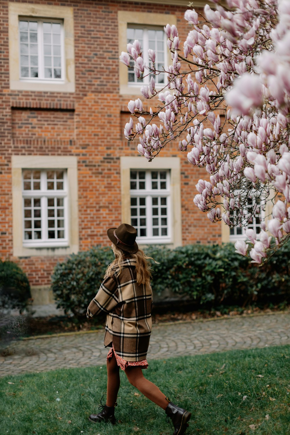 a woman walking in front of a brick building