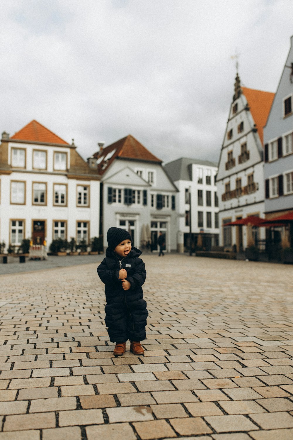 a small child standing on a brick road