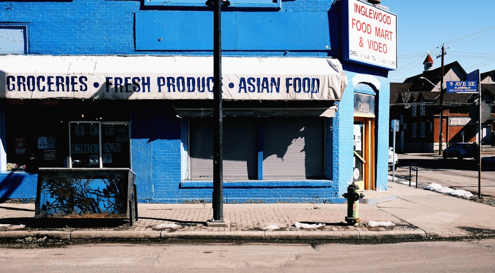 a street corner with a blue building and a fire hydrant