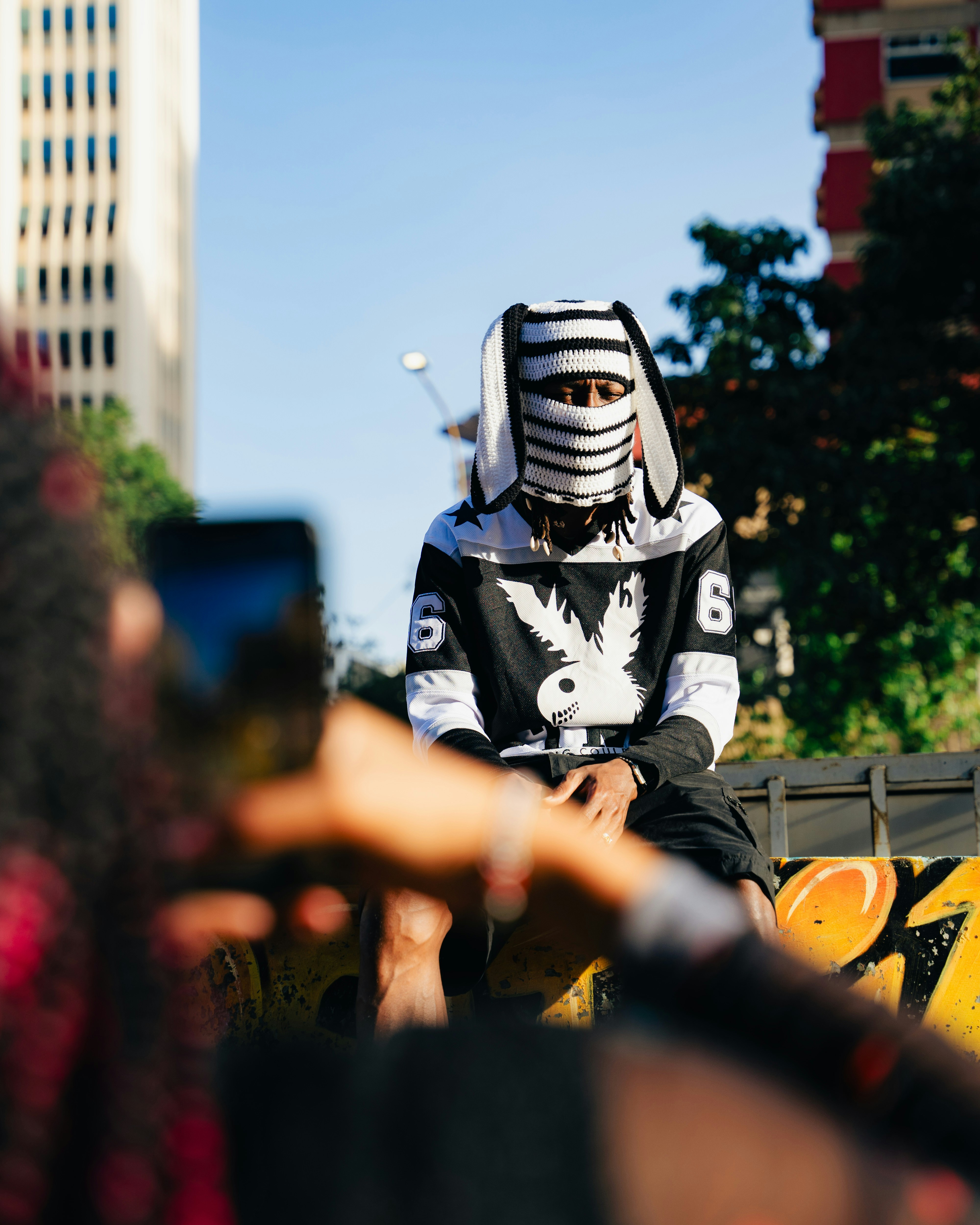Seorang pria berpakaian hitam putih duduk di truk kuning