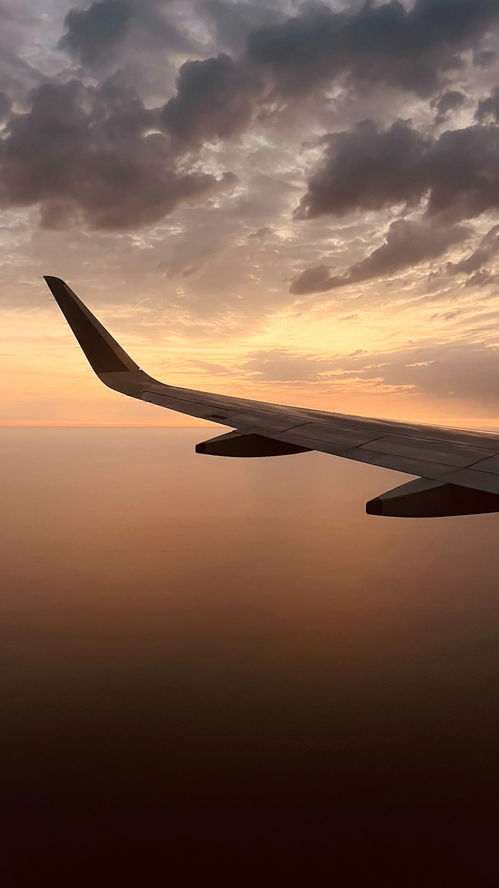 the wing of an airplane as the sun sets