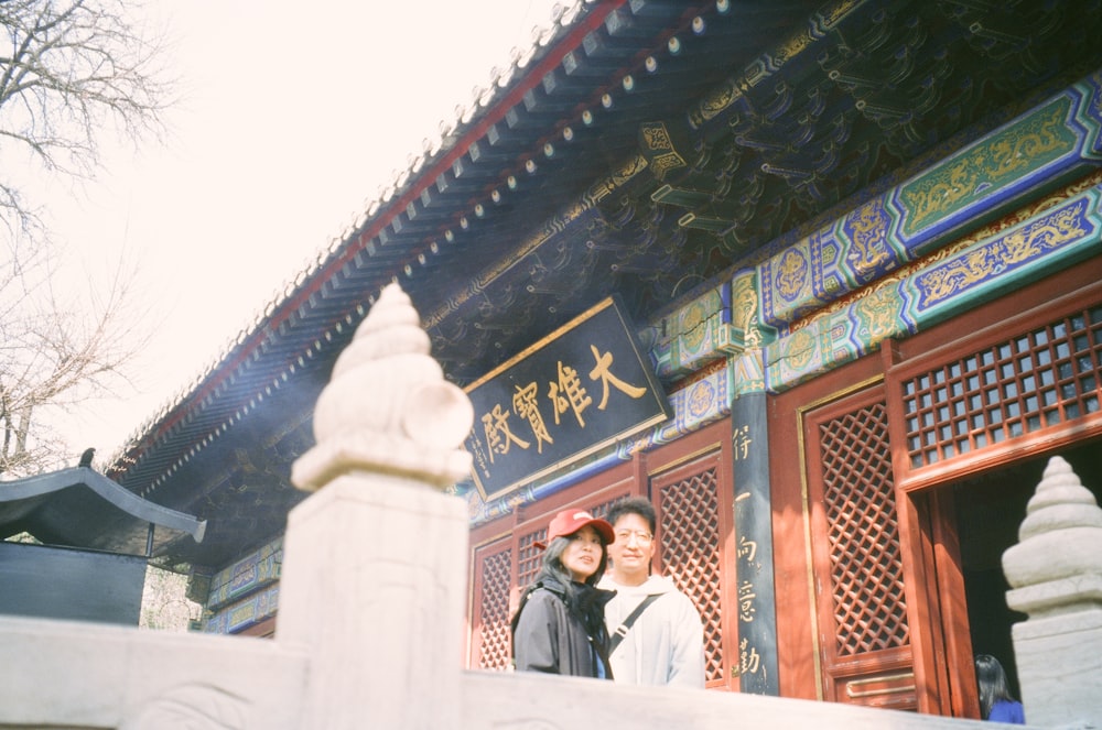 a couple of people standing in front of a building