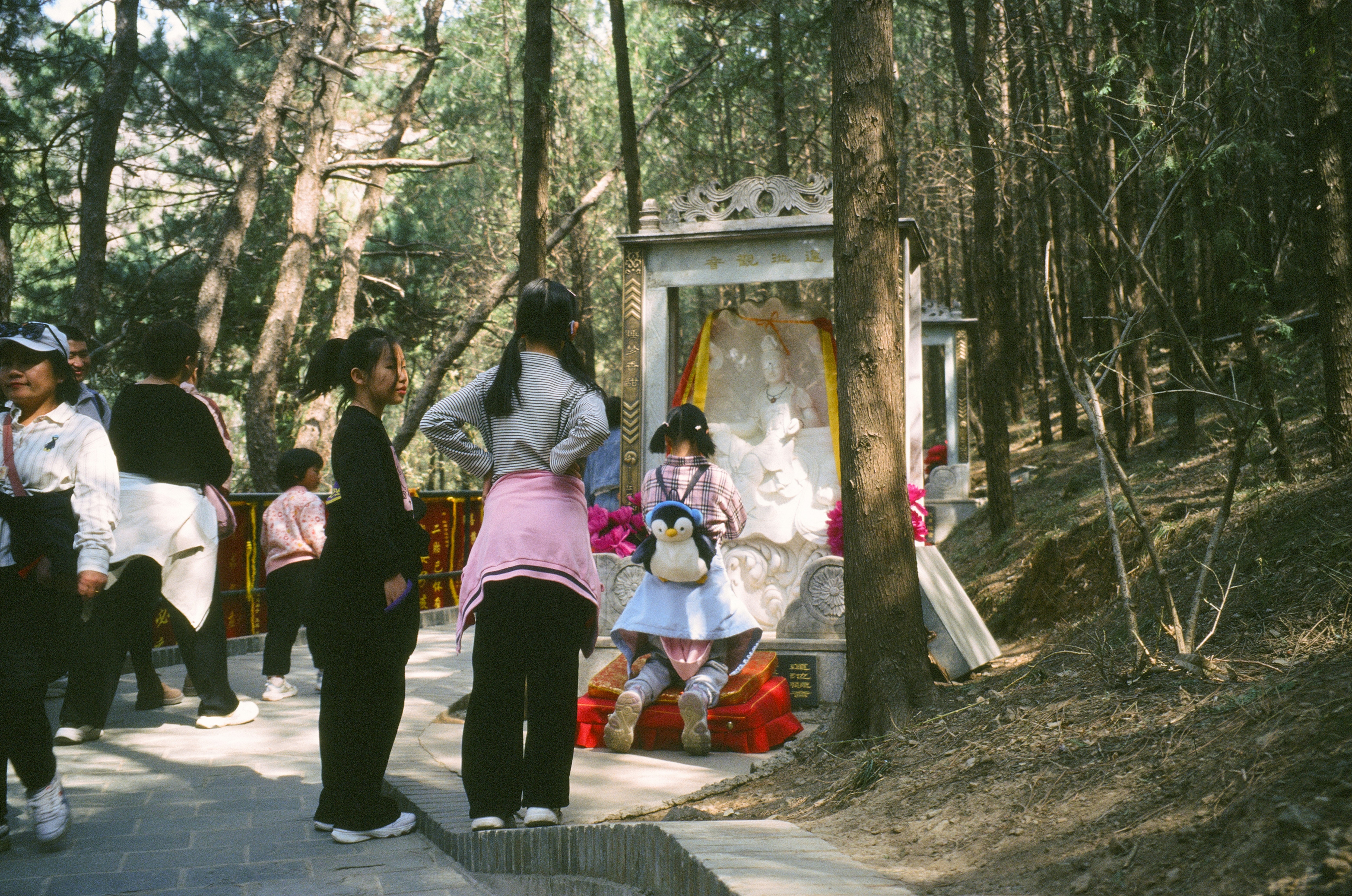 a group of people standing around a shrine in the woods
