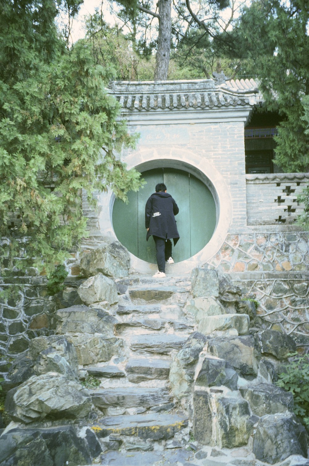 a man in a black coat walking up a set of stairs