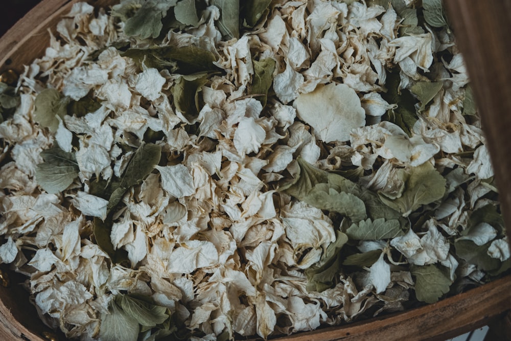 a wooden bowl filled with dried flowers and leaves