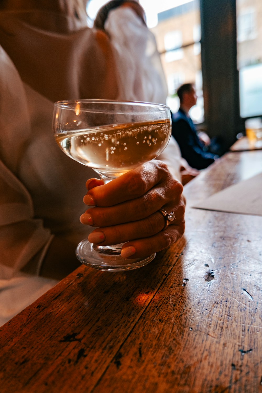 a person holding a glass of wine on a table