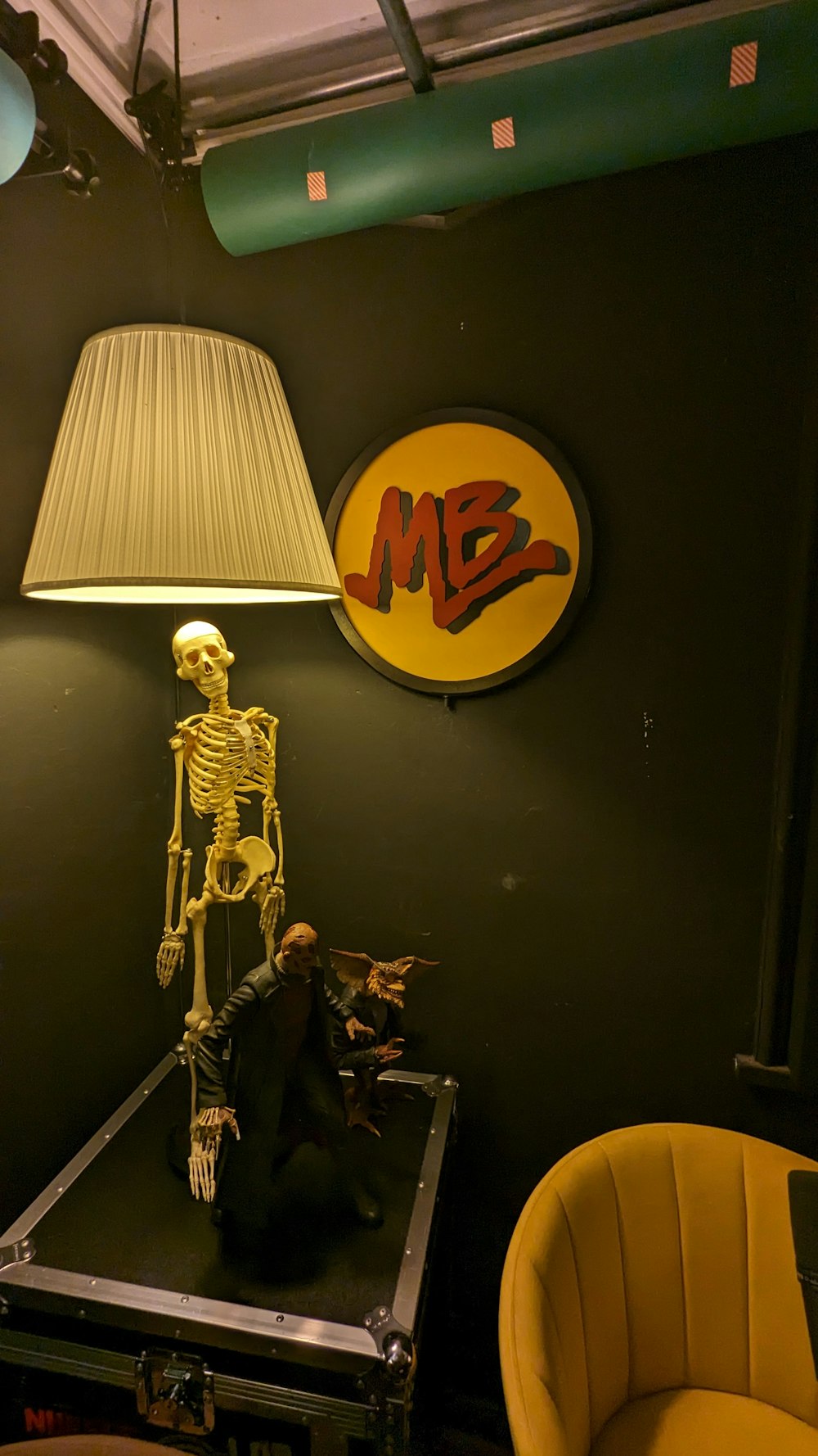 a skeleton sitting on top of a table next to a lamp
