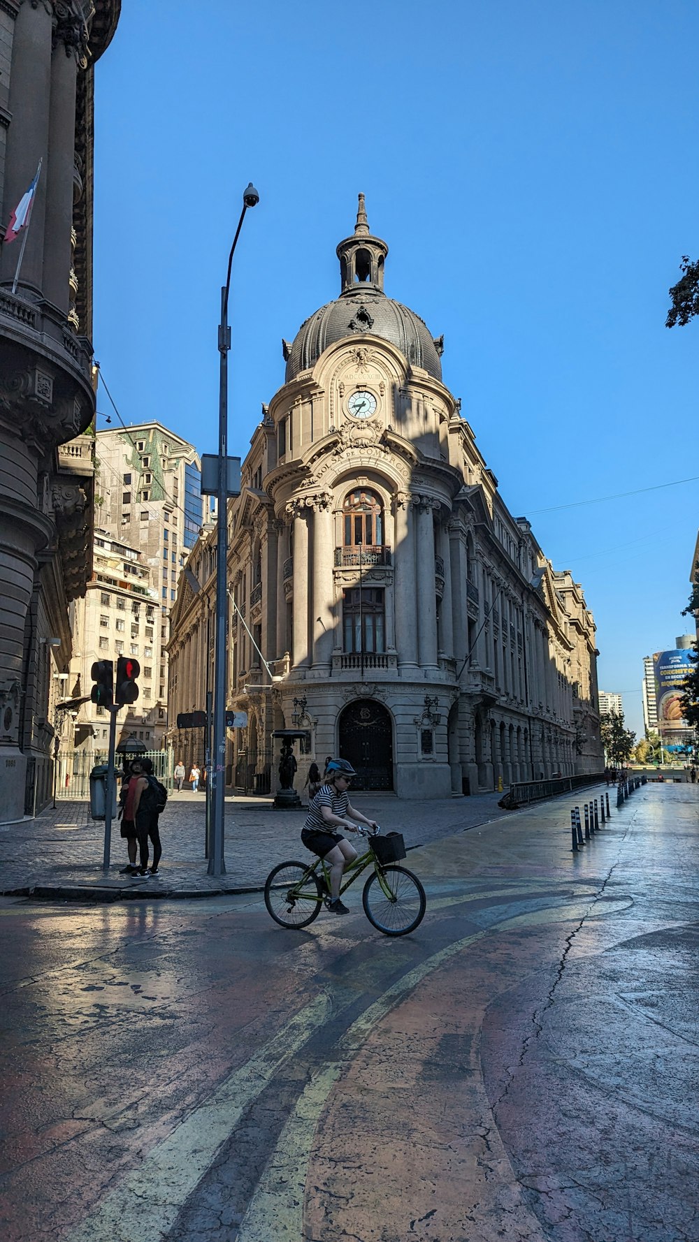 a man riding a bike down a street next to tall buildings