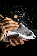 a person is holding a napkin with food flying out of it