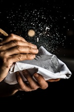 a person is holding a napkin with food flying out of it