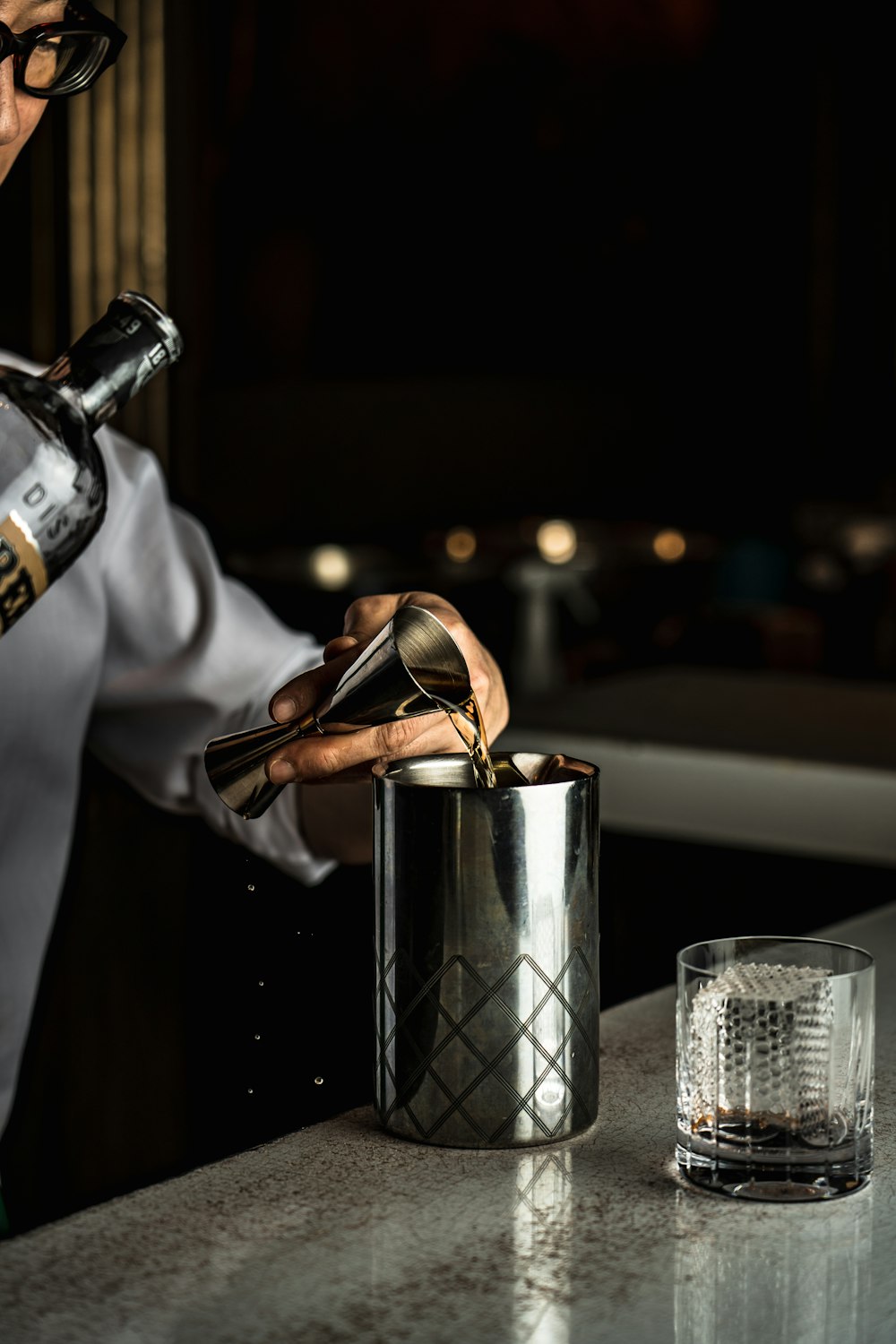 a man pouring a glass of wine into a bucket