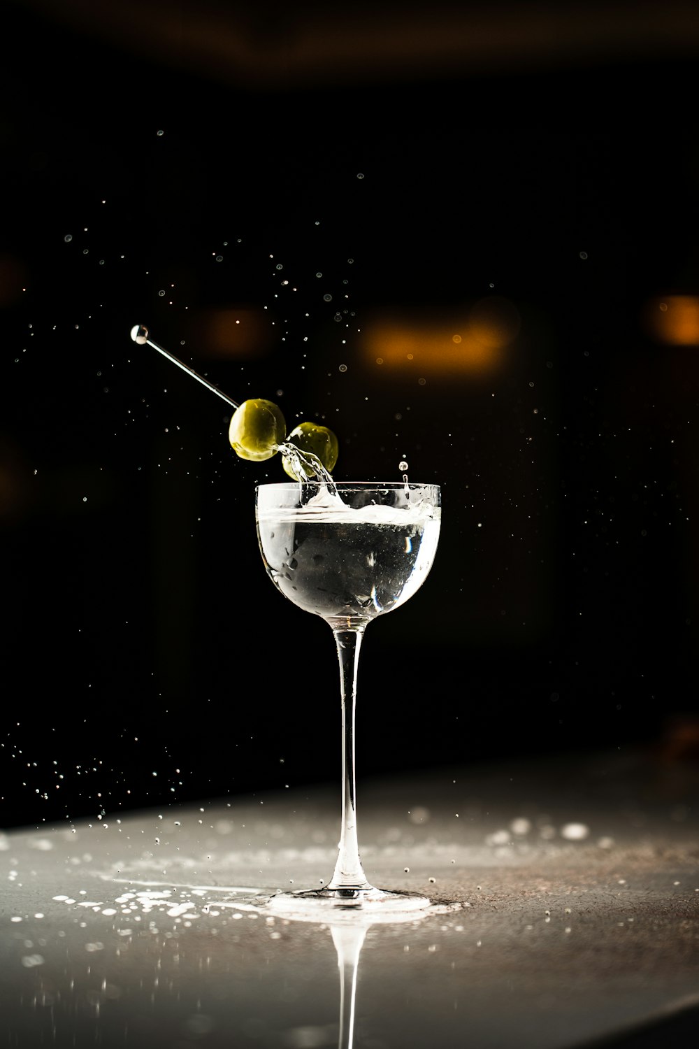 a martini glass with an olive garnish in it