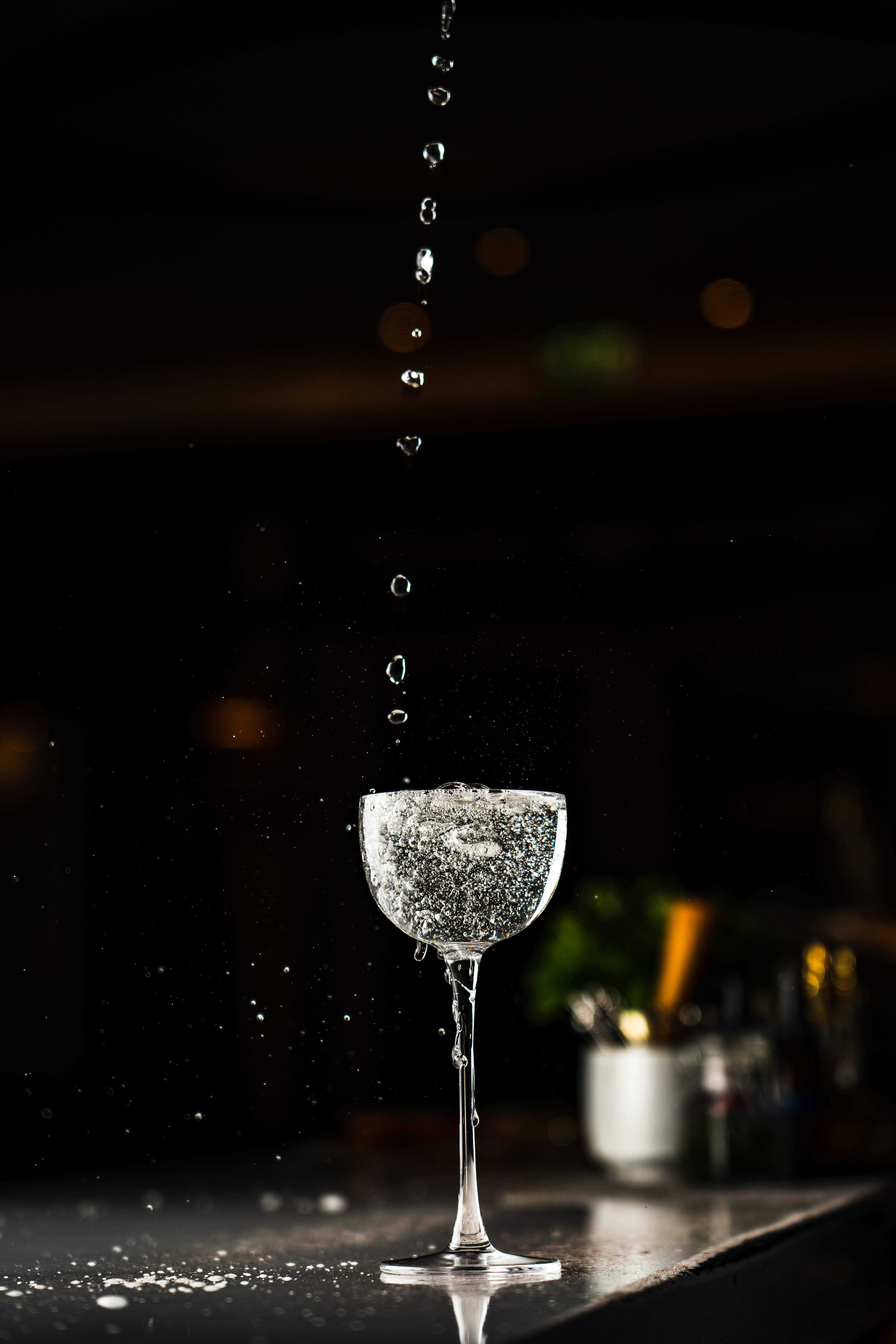 Sparkling water being poured into a coupe glass.