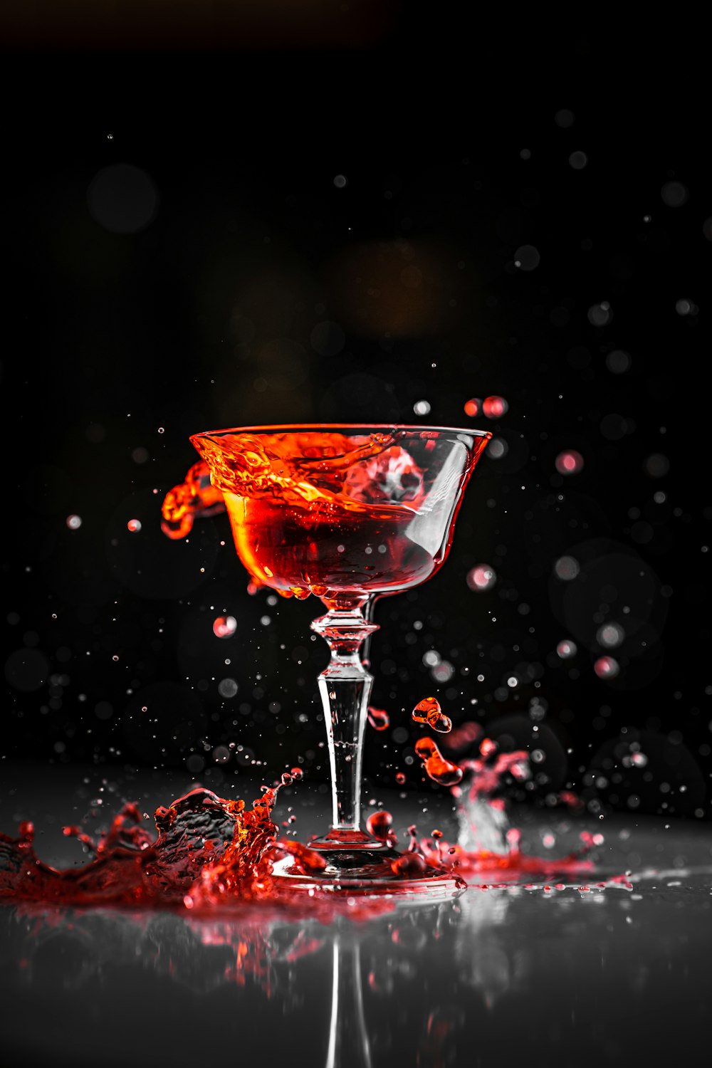 an orange liquid splashing out of a wine glass