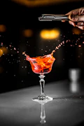 a person is pouring a drink into a glass