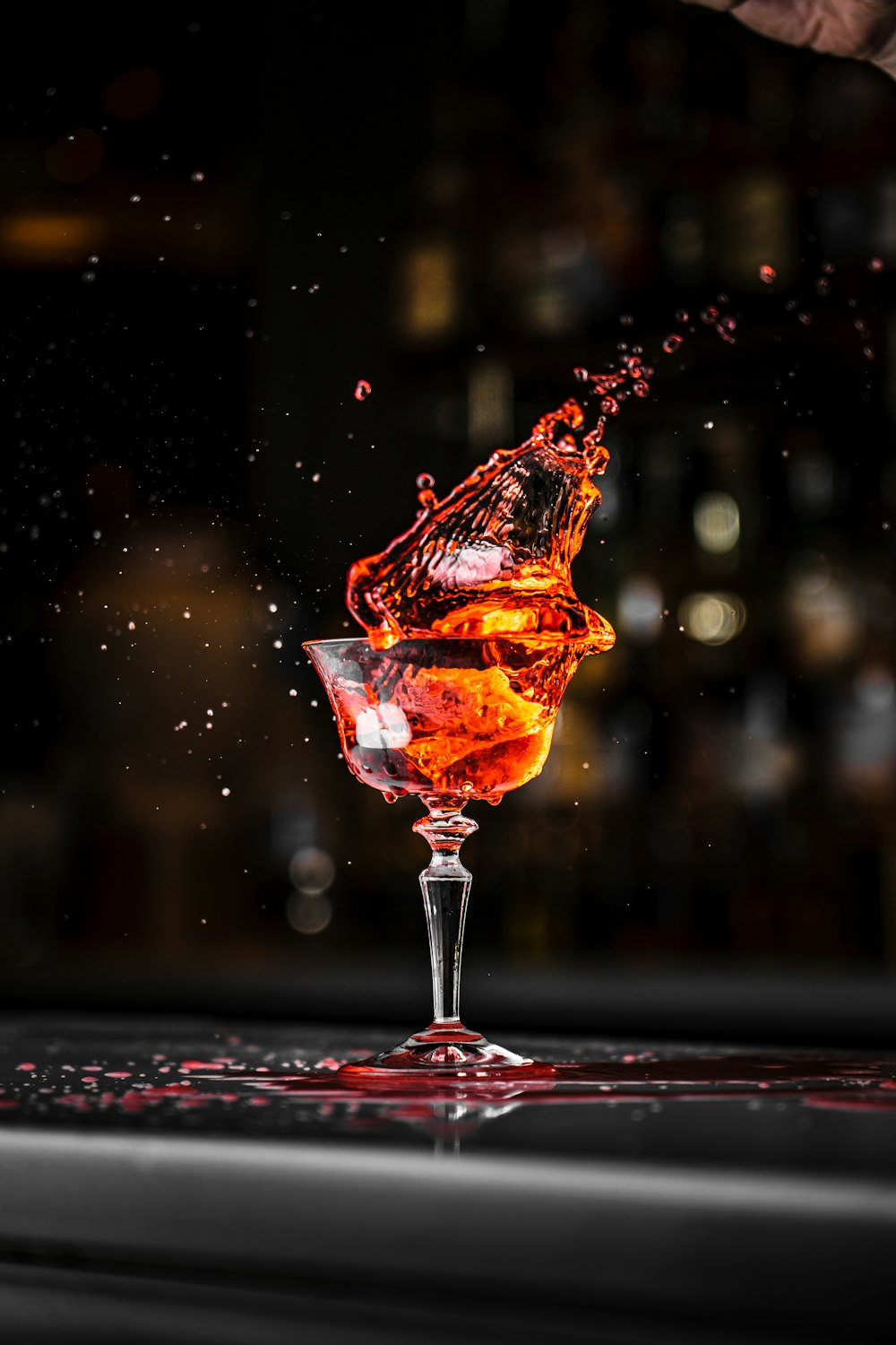 a person is pouring a drink into a glass