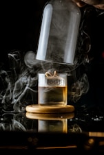 a glass of whiskey with smoke coming out of it