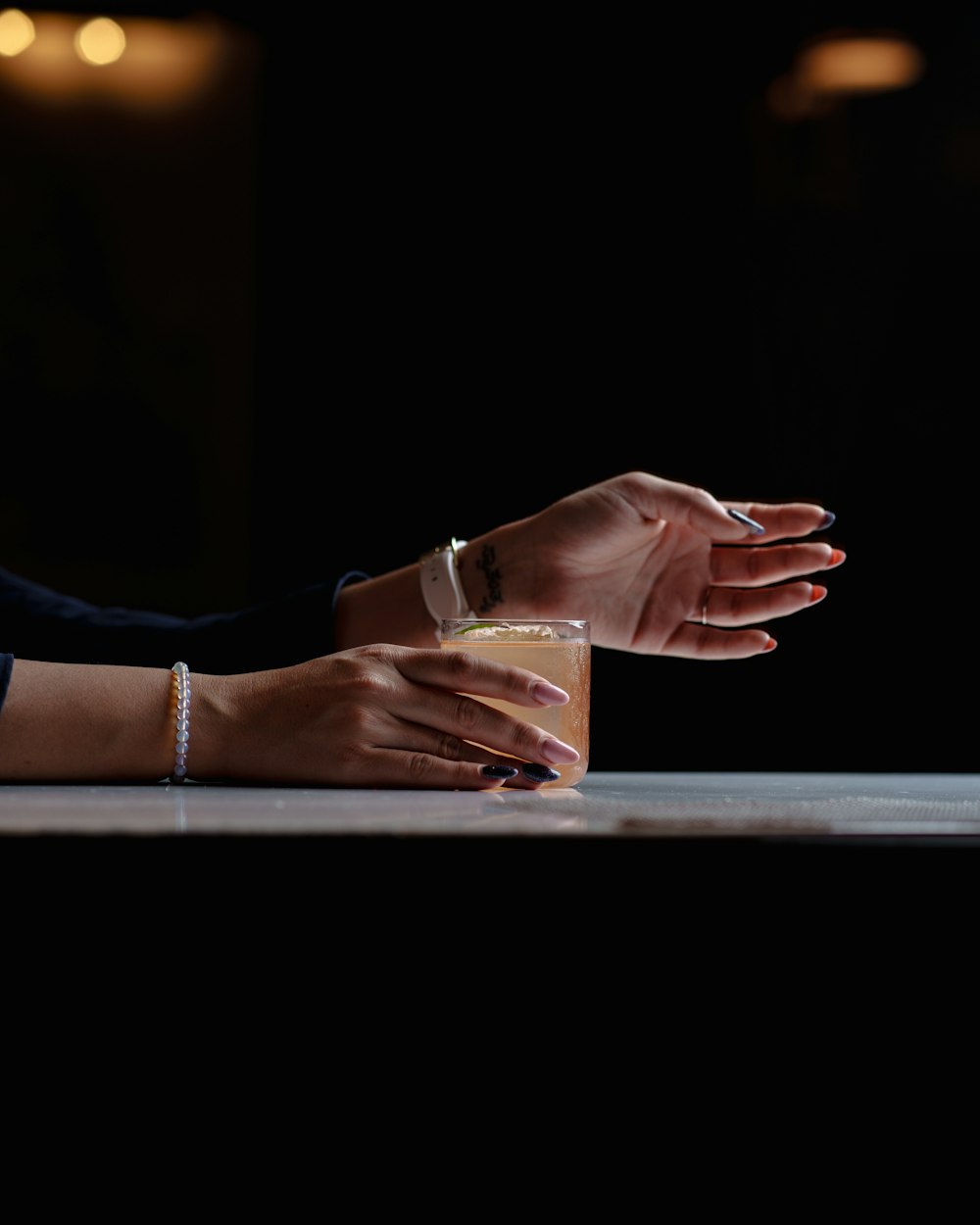 a woman sitting at a table with a glass of wine