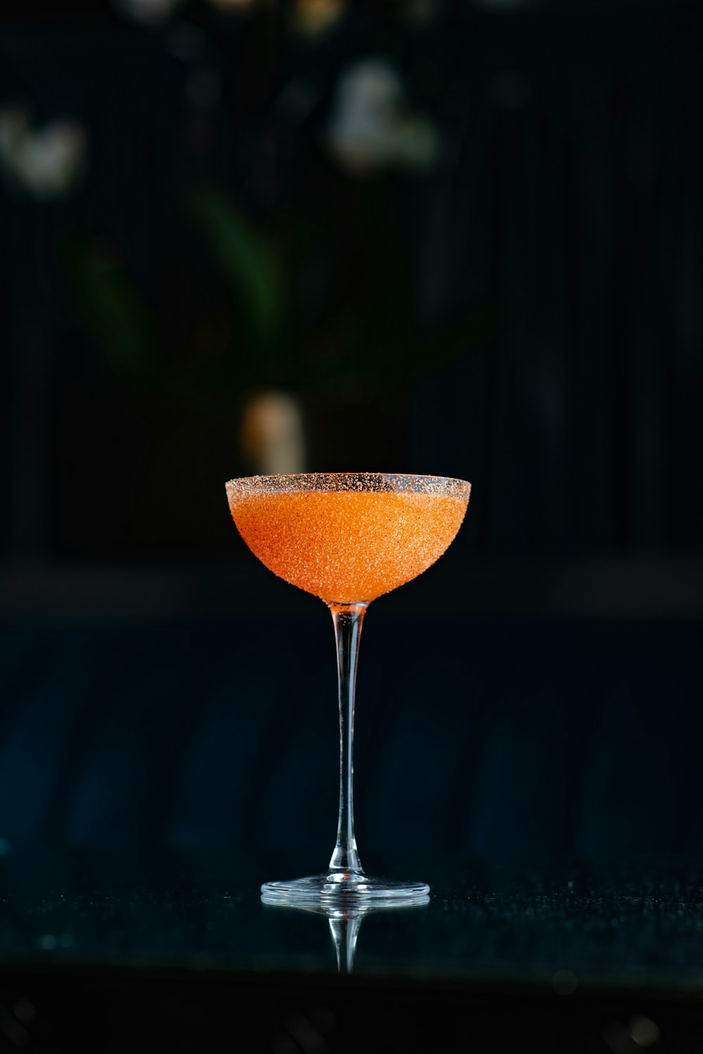 an orange drink in a glass on a table