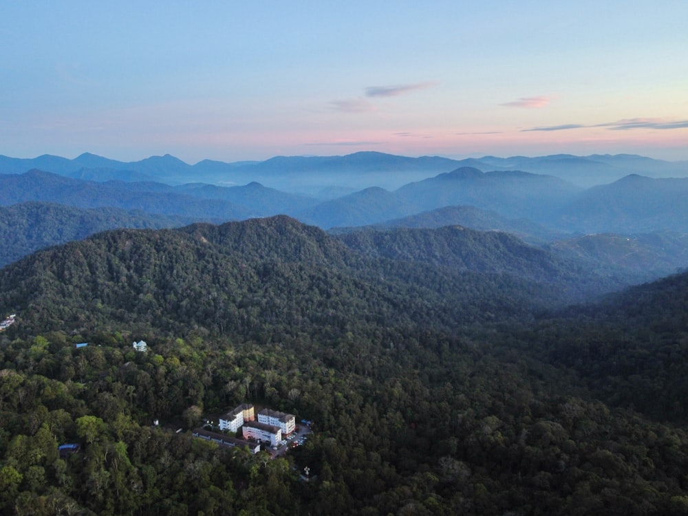 an aerial view of a mountain range with a building in the foreground