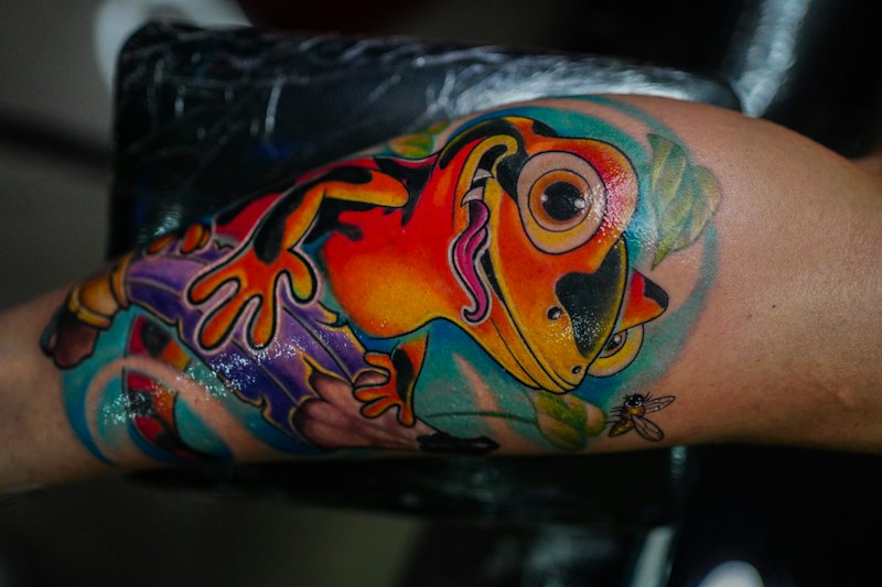 Colorful illustrative frog tattoo with painterly shading
