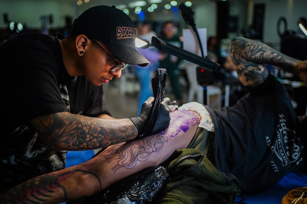 a man getting a tattoo on his leg
