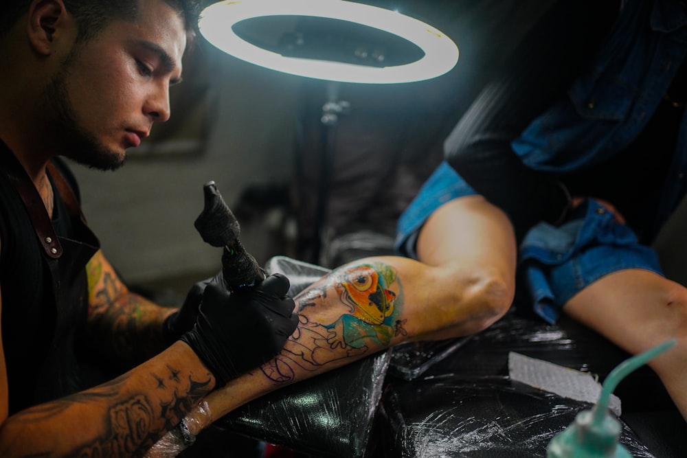 a man getting a tattoo on his arm