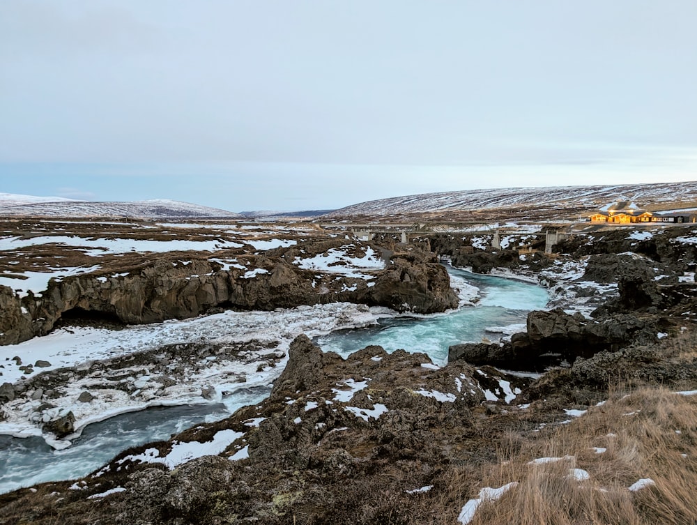 a river running through a rocky landscape covered in snow