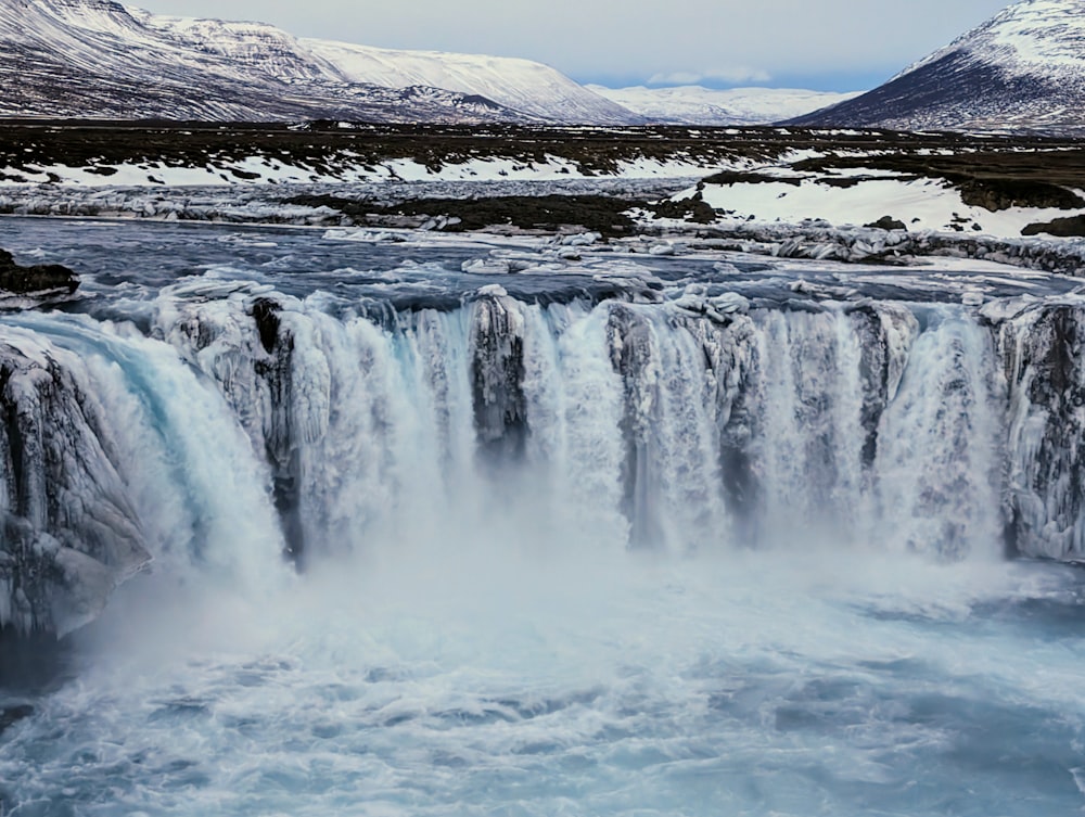 a large waterfall in the middle of a body of water