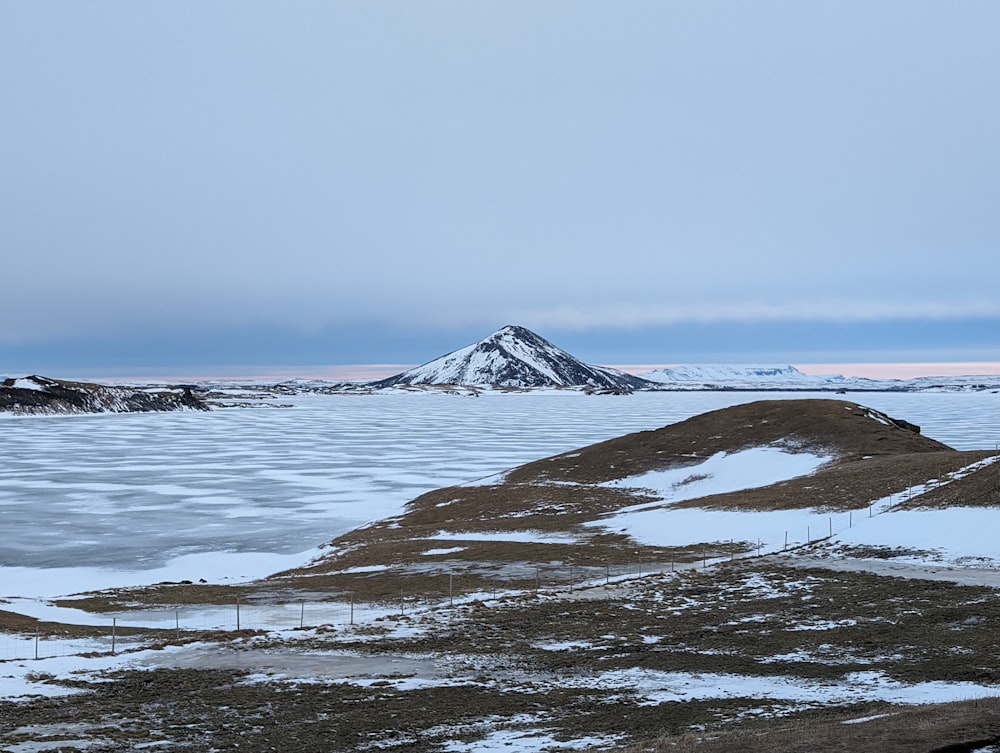 a snowy landscape with a mountain in the distance