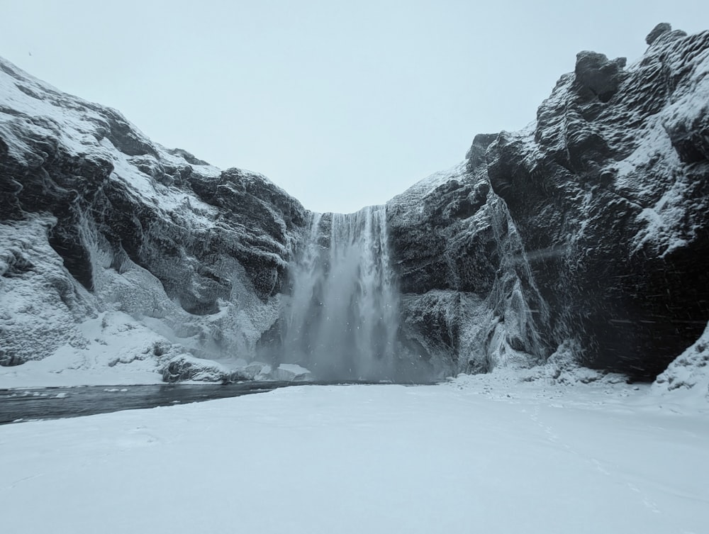 a large waterfall in the middle of a snowy landscape