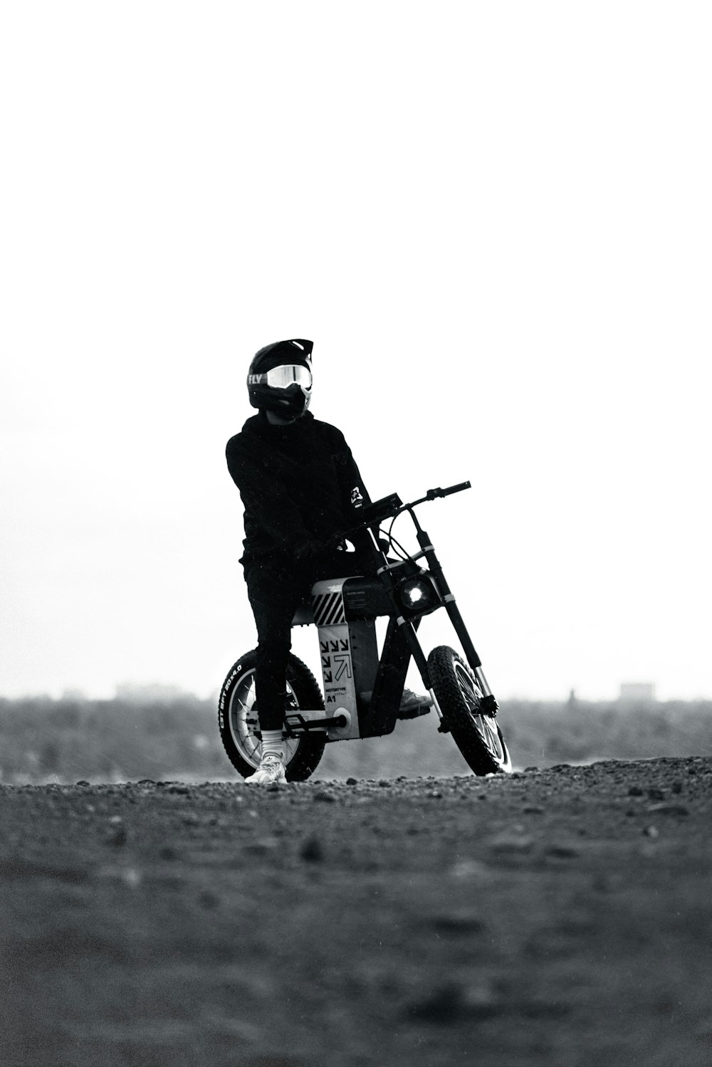uma foto em preto e branco de uma pessoa em uma motocicleta