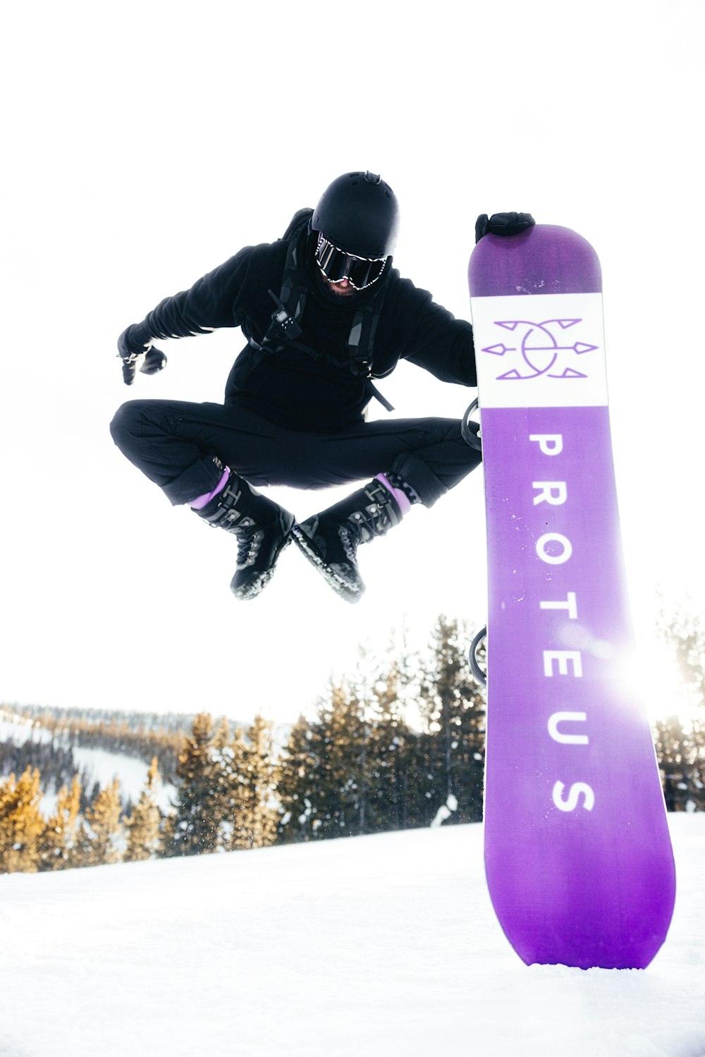 a man flying through the air while riding a snowboard