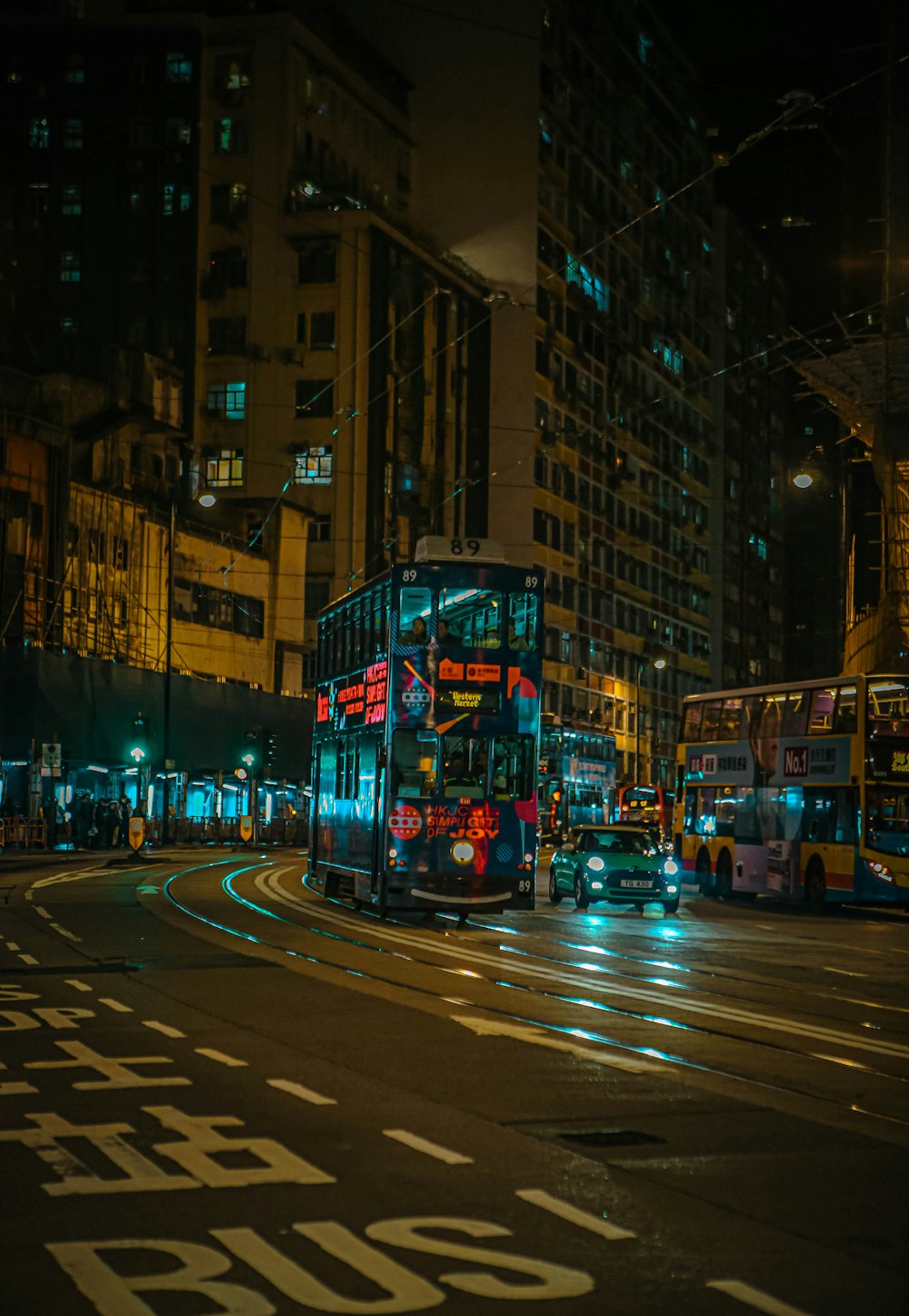 a double decker bus on a city street at night