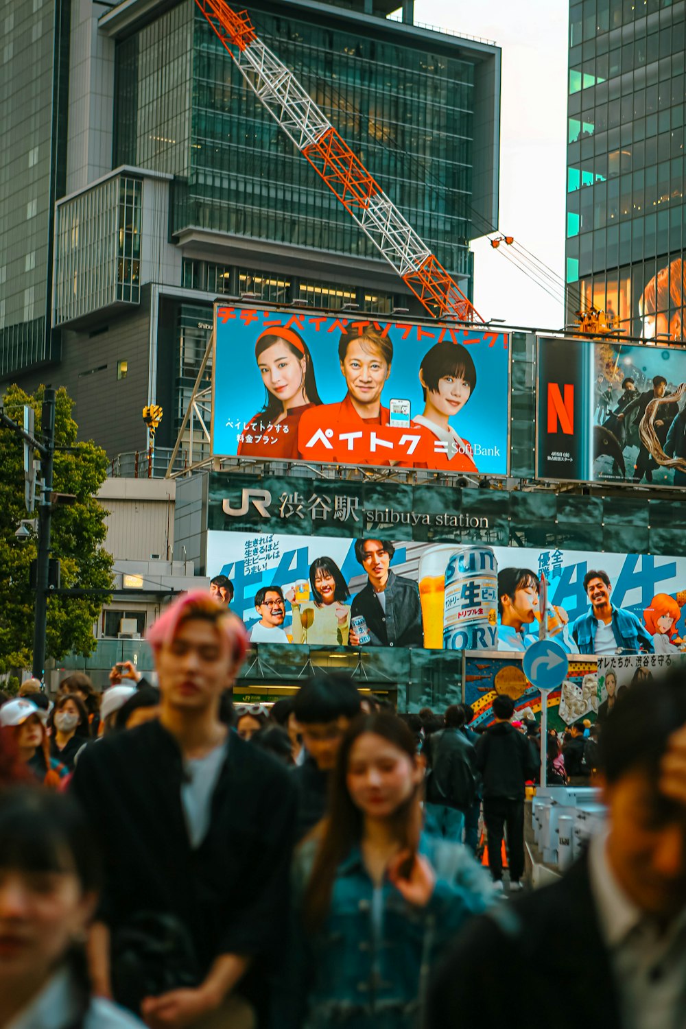 a crowd of people walking down a street next to tall buildings