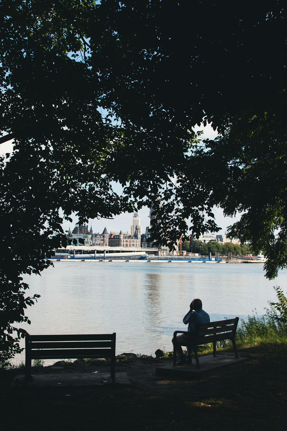 a person sitting on a bench near a body of water