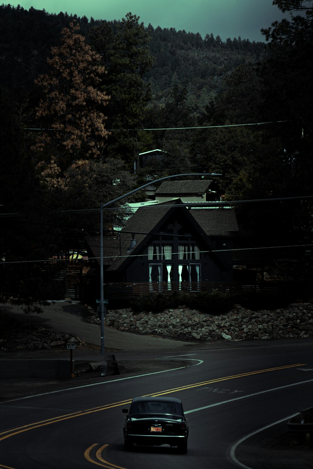 a car driving down the road in front of a house