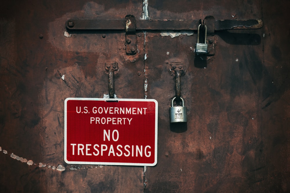 a no trespassing sign on a rusty door
