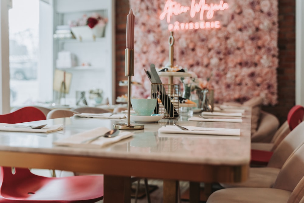 a restaurant with a long table and red chairs