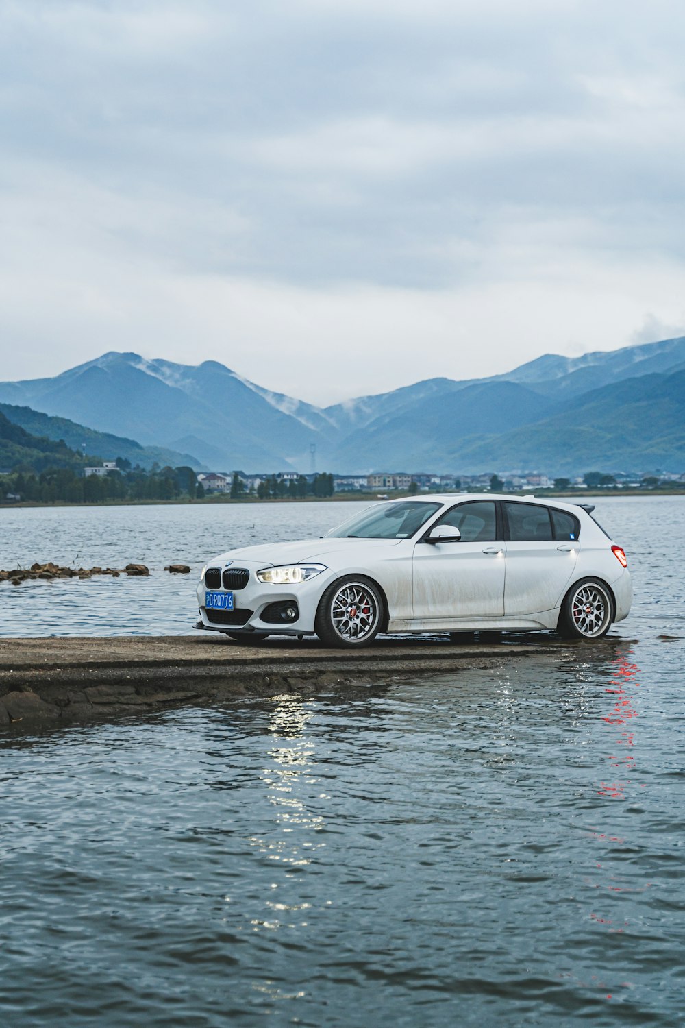 a white car sitting on top of a body of water